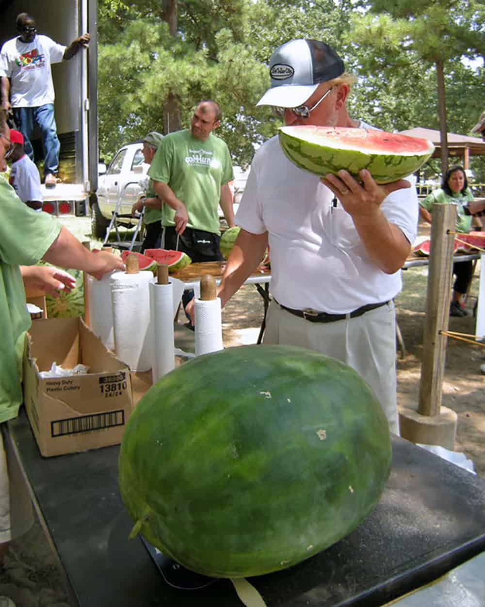 Arkansas Grows the Best: Big in Hope, Sweet in Cave City 2 2025 Watermelon Story for Arkansas Strong Hope Watermelon Festival man with slice by Kat Robinson