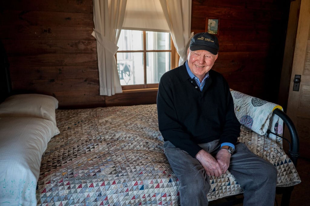 Carmie Henry sitting on Johnny Cash bed in the boyhood home of Cash in Dyess, Arkansas.